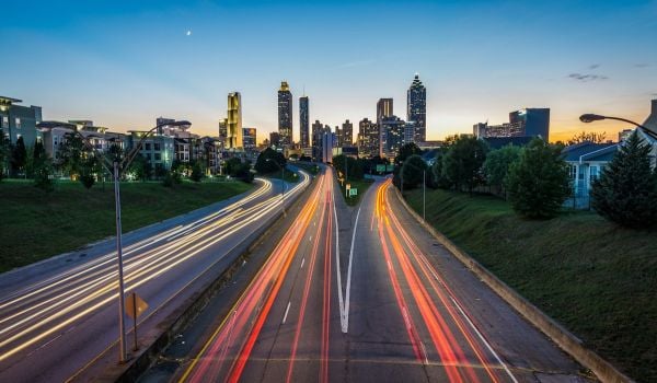 Light trails on a suburban highway; skyline with skyscrapers in the background