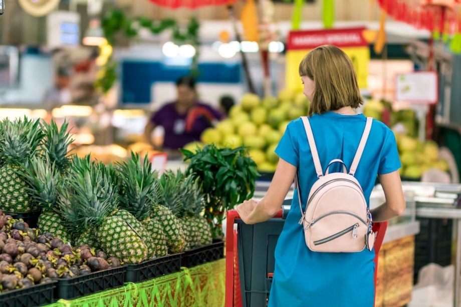 A woman pushing a cart through a supermarket