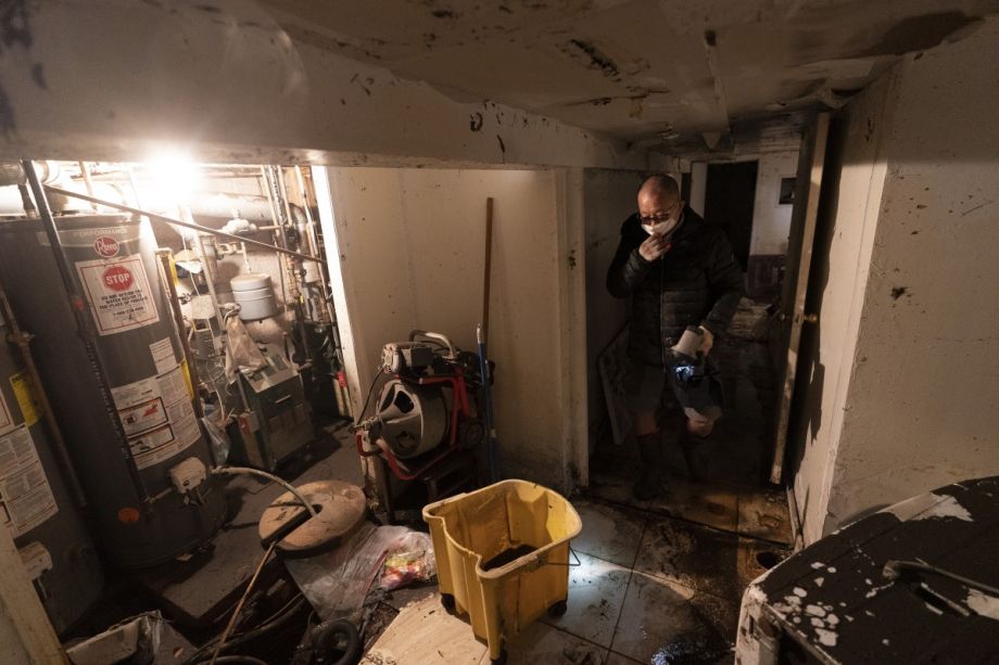 A man who gave his name as John helps to clean a friend's basement, Friday, Sept. 3, 2021, in Queens, New York. The area was flooded Wednesday as rain from the remnants of Hurricane Ida sent the New York City area into a state of emergency. 