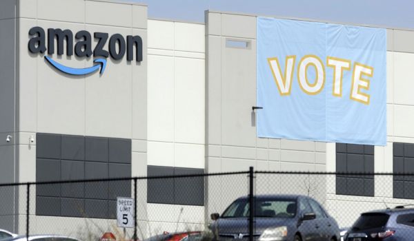In this March 30, 2021 file photo, a banner encouraging workers to vote in labor balloting is shown at an Amazon warehouse in Bessemer, Ala.