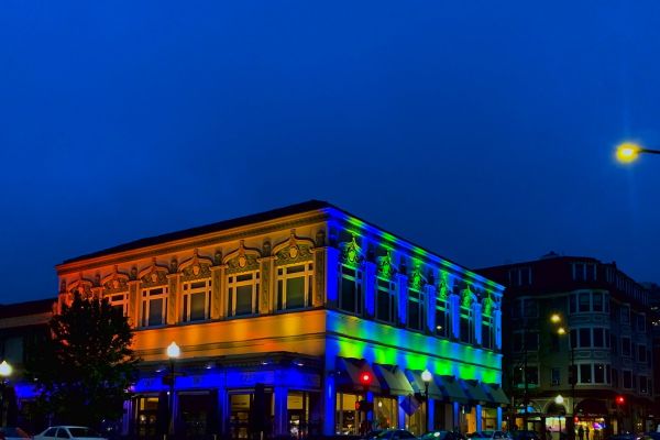 Blue, green and orange light reflects on building