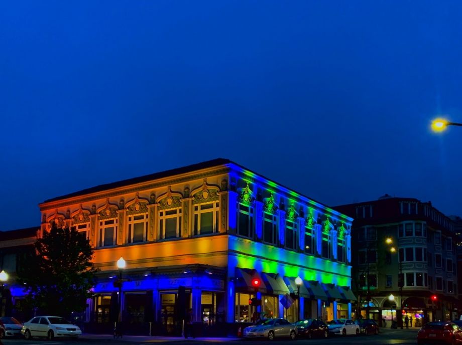 Blue, green and orange light reflects on building