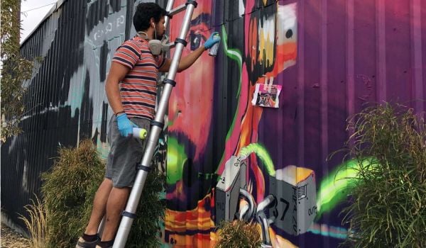 Artist Chris Fonseca installing a mural in the Live-Work-Create District in Garden City, Idaho.