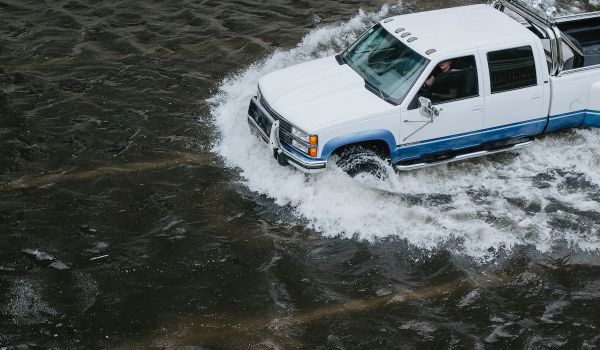 Person drives pickup truck through flooded street
