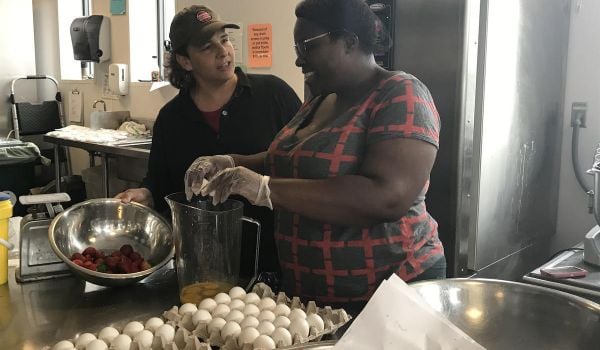 Jen Faigel and Sweet Teez Bakery owner Teresa Maynard work in the kitchen together.