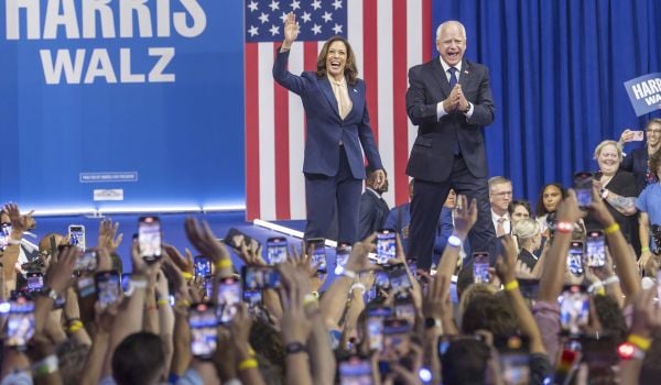 Kamala Harris and Tim Walz wave to crowd at rally.