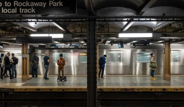 People stand on a subway platform in New York City
