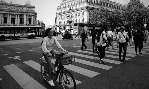 People crossing the street in a famous square (Place de l'Opéra) in Paris