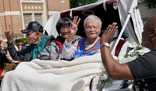 Hughes Van Ellis Sr., Lessie Benningfield Randle, and Viola Fletcher ride in a horse-drawn carriage
