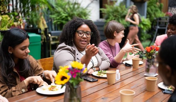 Group of people sitting at a wooden table and talking