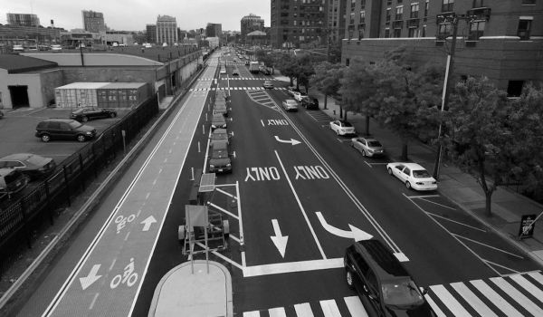 Aerial view of a street in Hoboken with lanes for vehicles, parking spots and protected bike lanes