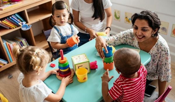 Childcare providers sit with children and talk with them