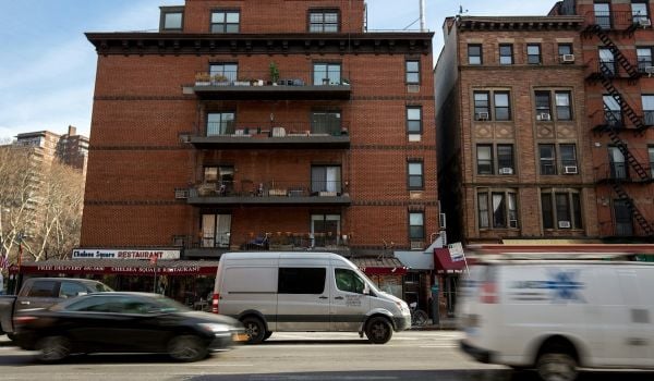 Cars driving in street; Apartment buildings in the background