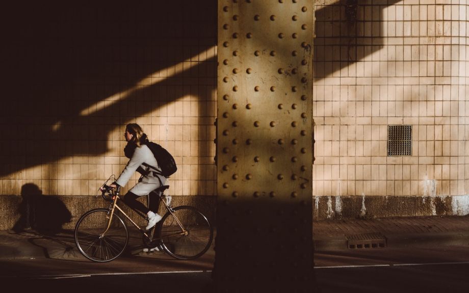 Person on a retro bike riding from the sunlight into the shadows.