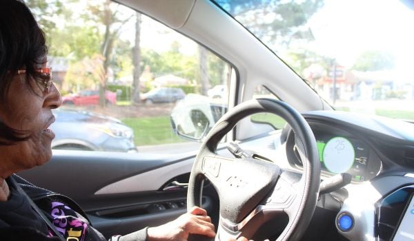 A woman drives an EV using a new carshare program.