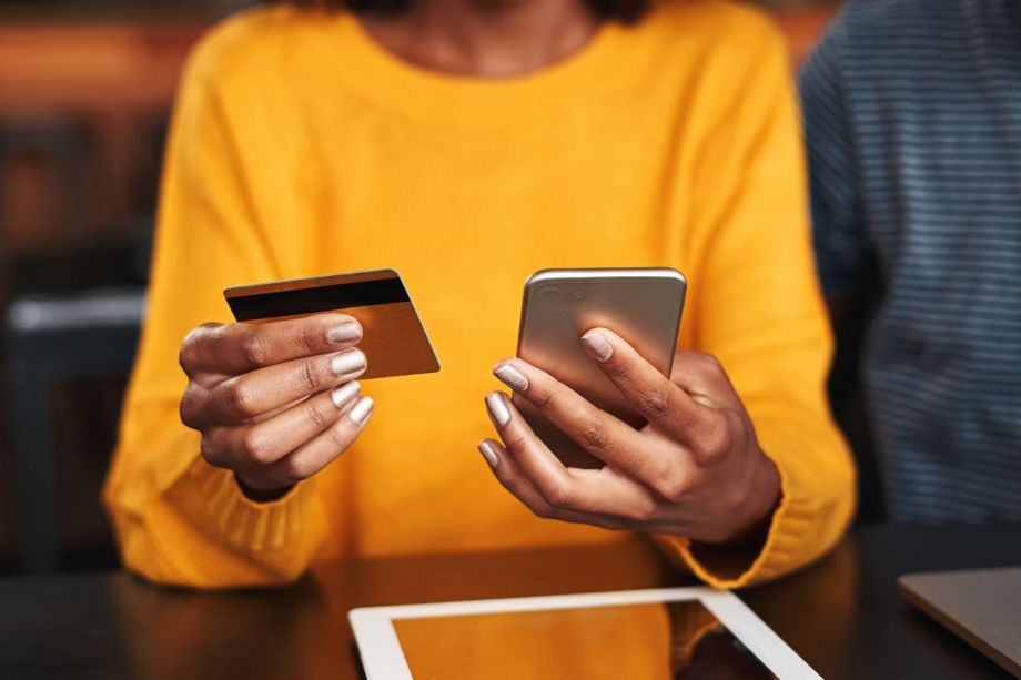 woman holding a credit card and phone