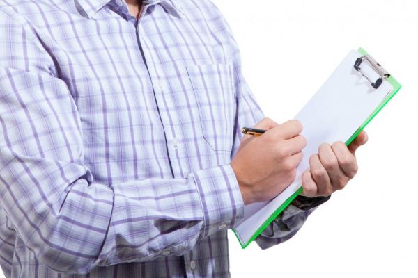 Man holding a clipboard filling out a survey or form