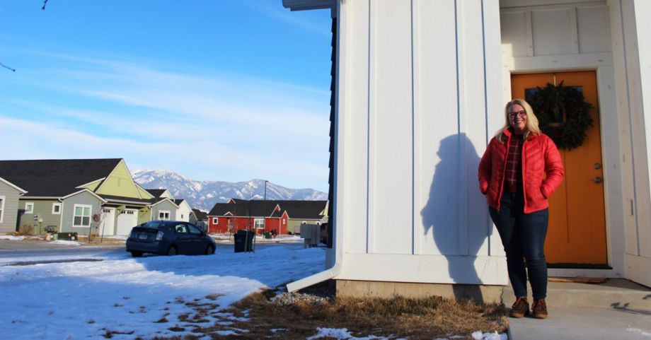Woman standing in front of Montana home with a mountain view