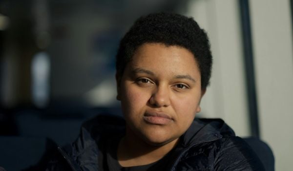 An agender adult looks at the camera.
