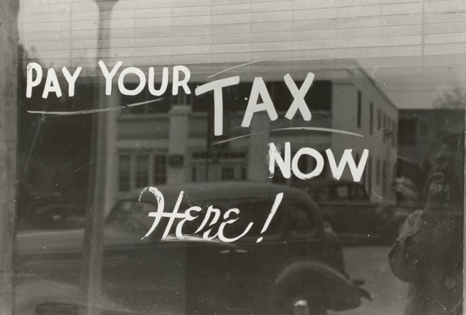 Words painted on a window read, 'Pay your tax now here!'