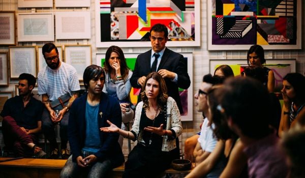 People site and talk in an art gallery