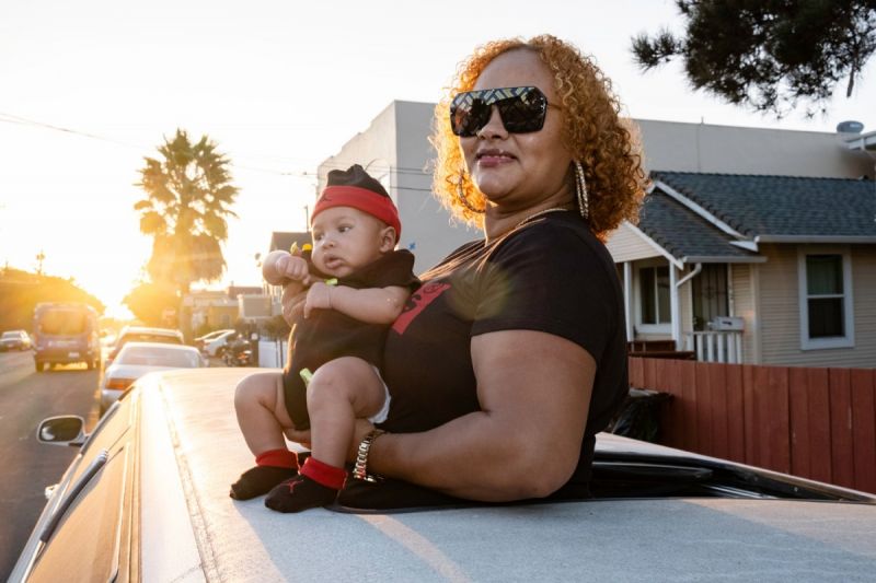 Tantay Tolbert holds her son for a portrait through a limousine sunroof in Richmond, CA, where she was provided a one-bedroom apartment through a subsidy program.