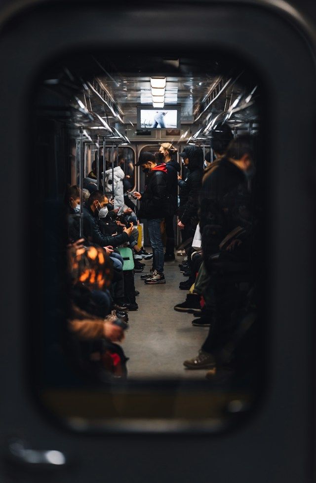 People can be seen on the train —some sitting and others standing — through a window